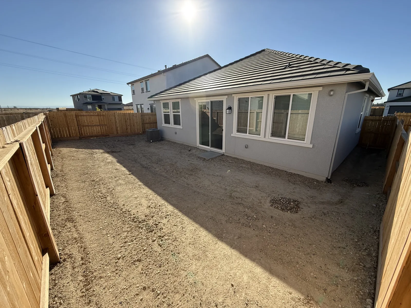 Bare dirt backyard of a newly built home before any hardscape or turf