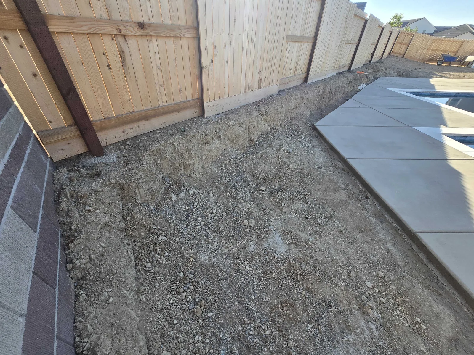 Low concrete retaining curb holding the grade along a new pool deck pour