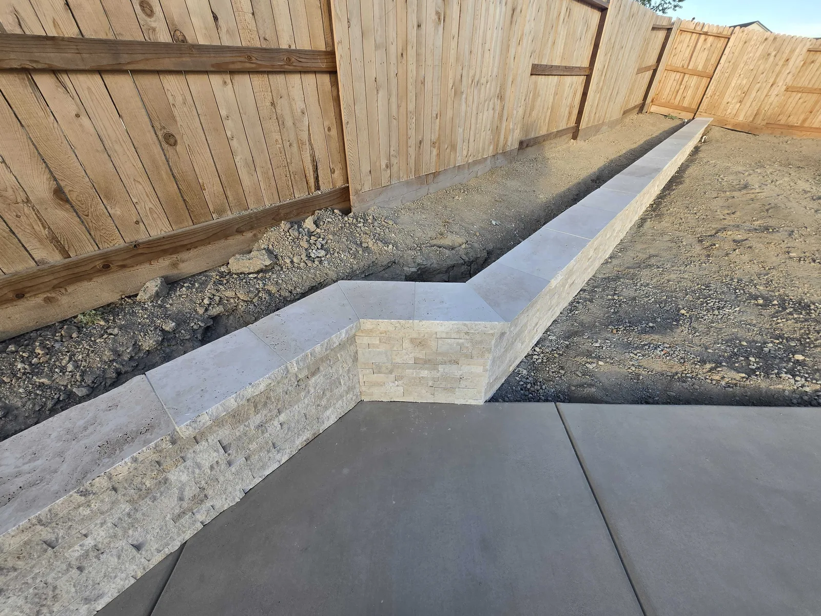Seat wall taking shape beside a freshly poured pool deck