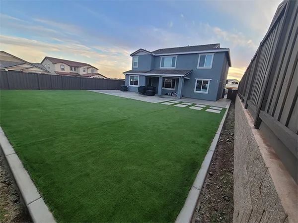 Backyard turf lawn with concrete curb border