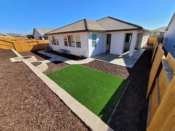 Finished side yard with turf and gravel-bordered drainage path in the Sacramento area