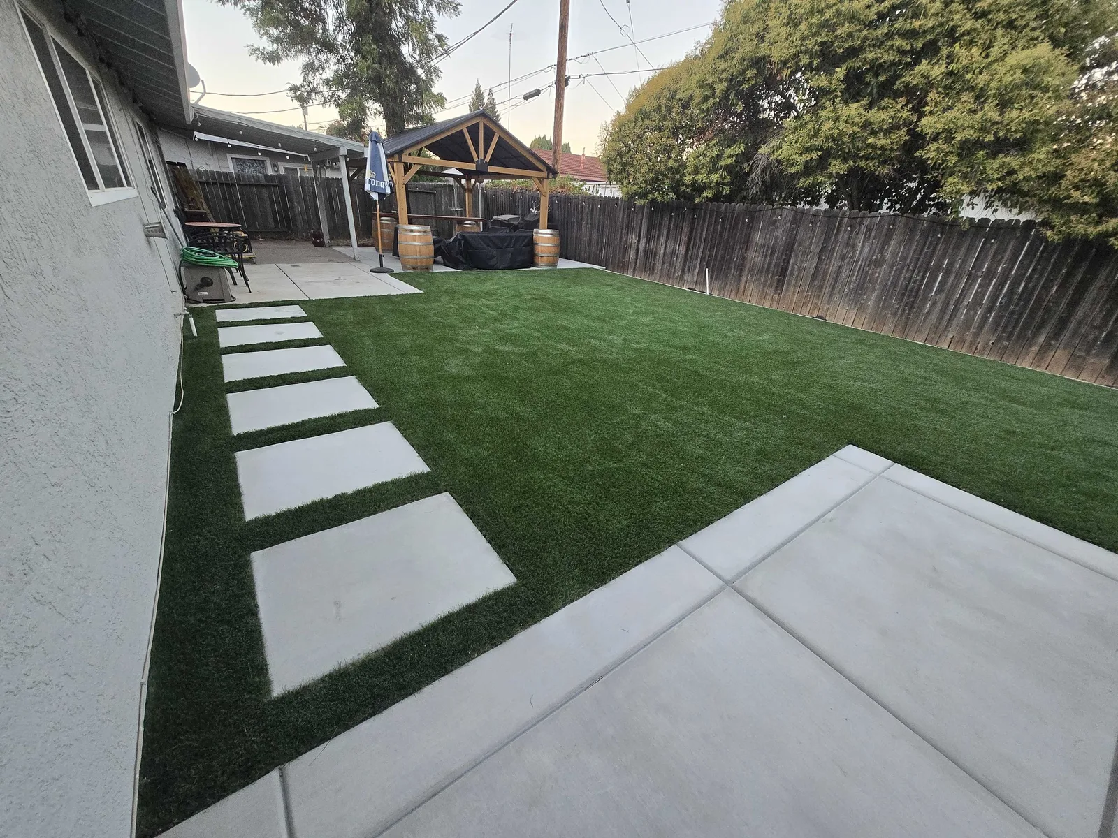 Concrete stepping pads set into artificial turf along a side yard